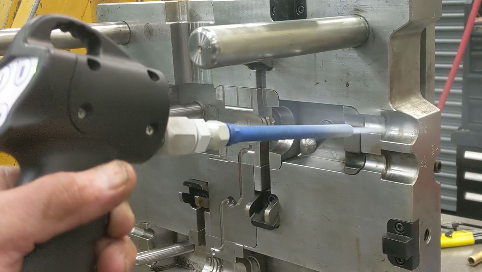 Pistolet de projection de glace carbonique nettoyant un moule d’injection plastique en atelier